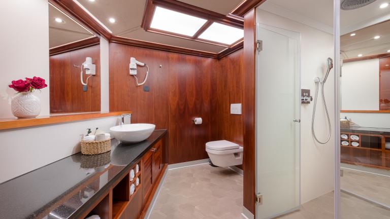 A simple bathroom made of fine wood with discreet decoration on the Lady Gita.